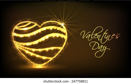 Shiny golden heart on brown background for Happy Valentines Day celebration.