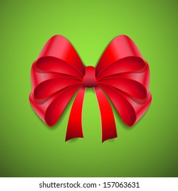 Shiny red satin ribbon on green background