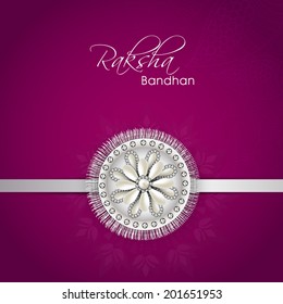 Shiny silver rakhi on purple background for the festival of Raksha Bandhan. 
