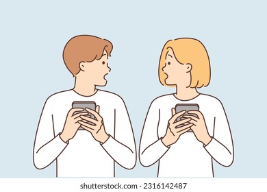 Shocked couple with phones surprised to read news or receive SMS mailing about bad weather. Embarrassed man and woman with phones surprised by posts or shared photos of partner on social media