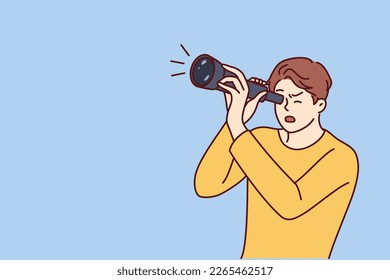 Shocked guy is looking through spyglass while looking at sights or watching rare astronomical phenomenon. Surprised man spying on neighbors using spyglass for uncoordinated surveillance