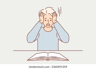 Shocked man reads book and tears hair out after learning scary facts from history or predictions for future. Frightened guy student looks into book and panics, feeling inability to prepare for exams