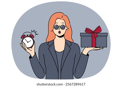 Shocked woman with gift and alarm clock in hands opens mouth in surprise after learning about being late for party. Businesswoman in formal black clothes and sunglasses holding gift for boyfriend