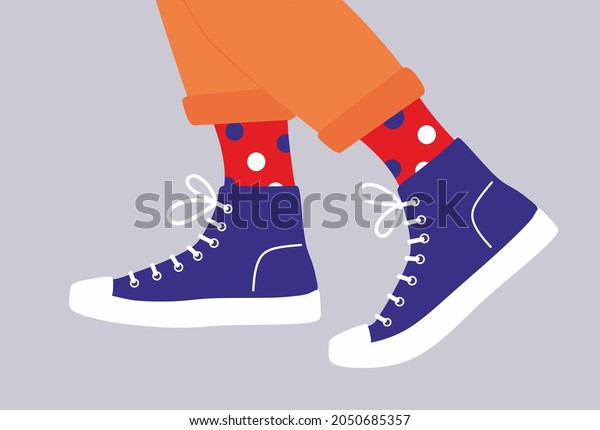 Shoe pair, boots, footwear. Canvas shoes.\
Feet legs walking in sneakers with colored socks and jeans. Fashion\
style high-top and low-top sneakers.Lace-up shoes. Color Isolated\
flat vector illustration