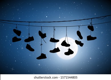 Shoes on wires on moonlit night. Vector illustration with silhouette of old shoes hanging on power lines. Full moon in starry sky