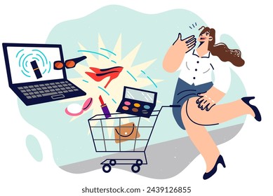 La mujer adicta a las compras en línea está haciendo compras en la computadora portátil, pidiendo zapatos y cosméticos, de pie cerca del carrito del supermercado. Chica adicta a la búsqueda de productos raros en Internet y las compras en los mercados.