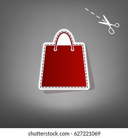 Shopping bag illustration. Vector. Red icon with for applique from paper with shadow on gray background with scissors.