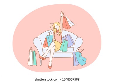 Shopping, sales, fashion, purchase concept. Happy smiling young blonde woman cartoon character sitting on sofa in boutique with heap of various colourful shopping bags after successful shopping