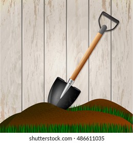 Shovel in the ground. Gardening tool on wooden fence background. Isolated shovel in heap of soil