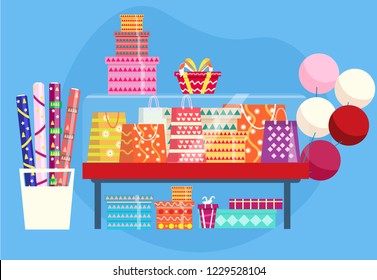 Showcase with gift bags, present boxes, rolls of wrapping paper and baloons.