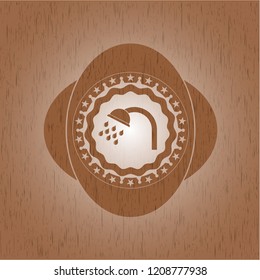 shower icon inside badge with wooden background