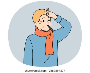 Sick flu boy with thermometer in mouth touching forehead with fever and in need antibiotics to fight infection. Sick child suffers from disease caused by hypothermia and problems with immune system