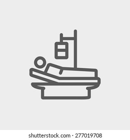 Sick man resting in bed with IV saline solution icon thin line for web and mobile, modern minimalistic flat design. Vector dark grey icon on light grey background.