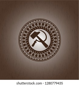 sickle and hammer icon inside badge with wood background
