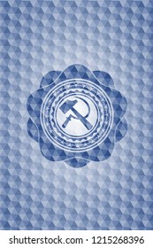 sickle and hammer icon inside blue emblem with geometric background.