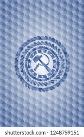 sickle and hammer icon inside blue emblem with geometric pattern background.