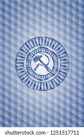 sickle and hammer icon inside blue hexagon badge.