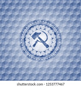 sickle and hammer icon inside blue badge with geometric pattern.