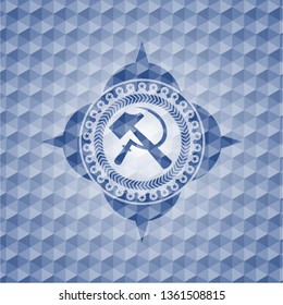 sickle and hammer icon inside blue emblem or badge with abstract geometric polygonal pattern background.