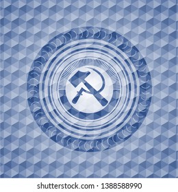 sickle and hammer icon inside blue badge with geometric pattern.