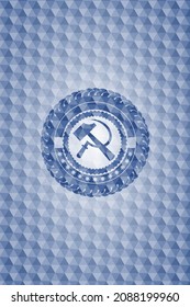 Sichel- und Hammer-Symbol in blauem Emblem oder Abzeichen mit abstraktem geometrischem Musterhintergrund. 