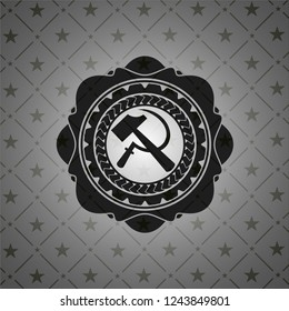 sickle and hammer icon inside dark badge or emblem