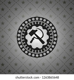 sickle and hammer icon inside dark badge or emblem