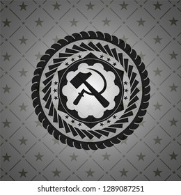 sickle and hammer icon inside dark badge or emblem