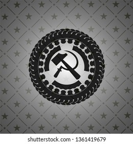 sickle and hammer icon inside dark badge or emblem