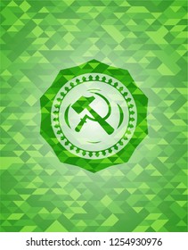 sickle and hammer icon inside green mosaic emblem