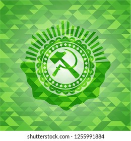 sickle and hammer icon inside green mosaic emblem