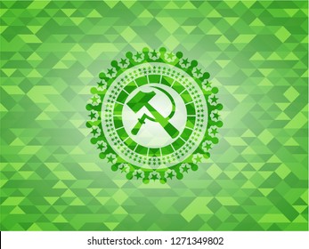 sickle and hammer icon inside green emblem with mosaic background