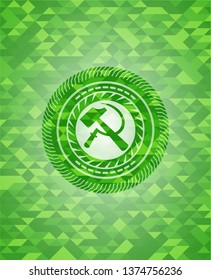 sickle and hammer icon inside green emblem with mosaic background