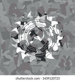 sickle and hammer icon inside grey camouflage emblem