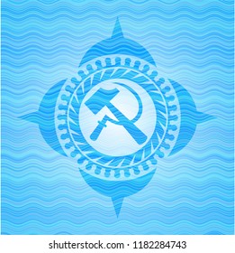 sickle and hammer icon inside light blue water wave emblem background.