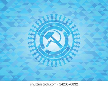 sickle and hammer icon inside light blue mosaic emblem