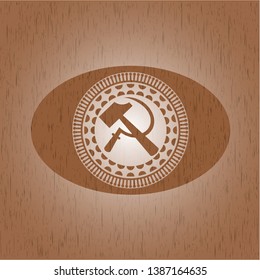 sickle and hammer icon inside wooden emblem