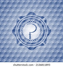 icono de la hoz dentro del emblema azul o placa con fondo de patrón geométrico. 