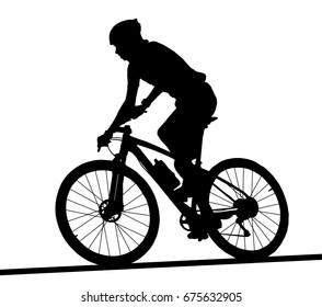 Side profile silhouette of male mountain bike racer riding bicycle  