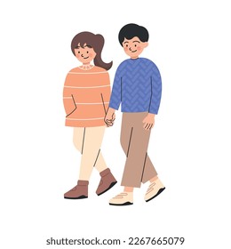 Side view of couple of teenagers walking together happily holding hands in winter outfit