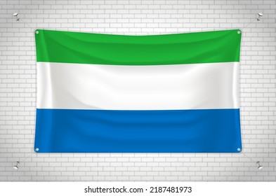 Sierra Leone flag hanging on brick wall. 3D drawing. Flag attached to the wall. Neatly drawing in groups on separate layers for easy editing.