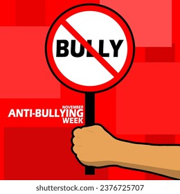 A sign prohibiting bullying is being held in a hand, with bold text on red background to commemorate Anti-Bullying Week on November