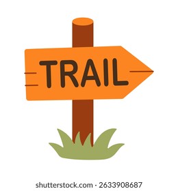 A sign that says Trail is on a wooden post. The sign is orange and has a green arrow pointing to the right