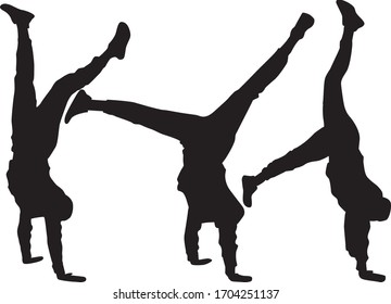 Silhouette of agile young man doing a handstand.