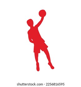 silhouette of a basketball player carrying the ball is throwing it into the hoop