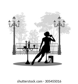 Silhouette of beautiful girl sitting in cafe.
