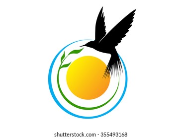 A silhouette of a bird against the sky, the sun and a tree with leaves