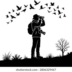 Silhouette of bird watcher using binoculars outdoors