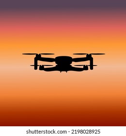 
silhouette of a black quadrocopter on the background of the sunset sky