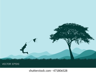 silhouette of A boy jumping with kite to fly. sunset